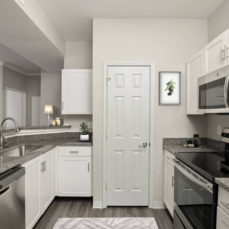 White cabinetry, granite, stainless steel & plank flooring